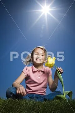 Portrait of a girl sitting beside a flower Stock Photos