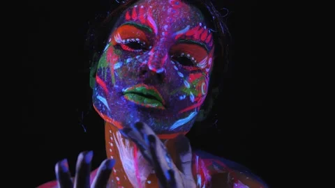 Portrait of girl with a UV pattern on her face, she slowly moves her hands. Stock Footage 145766744