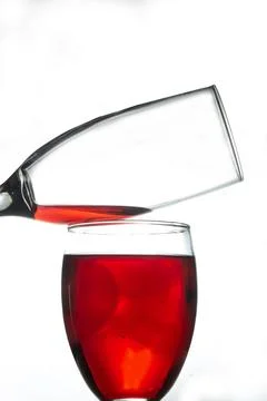 Portrait of a glass of red liquid upside down and a cup of liquid poured Stock Photos