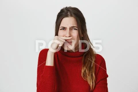 Portrait of gloomy attractive european girl with rainy nose holding her index Stock Photos