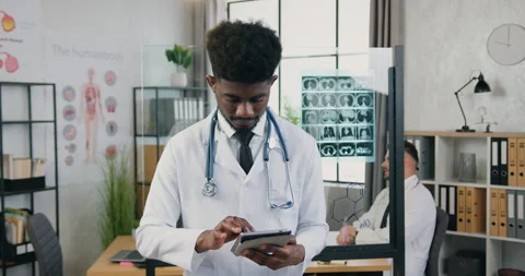 Portrait of good-looking joyful young skilled black-skinned medical worker which Stock Footage 160417353
