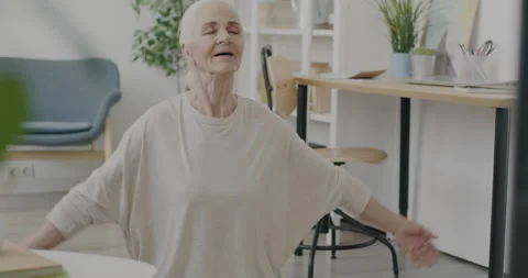 Portrait of good-looking old lady doing yoga watching TV and smiling feeling Stock Footage 237318005