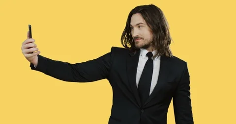 Portrait of the good looking young man in the suit and tie making nice selfies Stock Footage 104165304