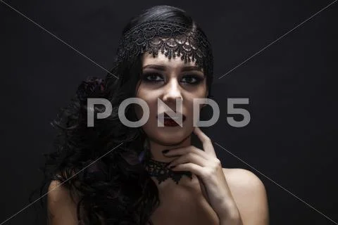 Portrait of a gorgeous brunette with a hat over black background. Halloween. Stock Photos