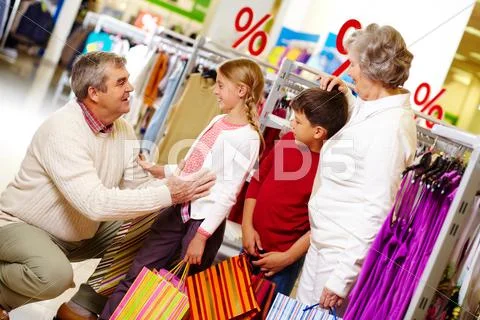 Portrait of grandparents and grandchildren in clothing department Stock Photos