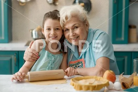 Portrait of granny and grandaughter at the kitchen table Stock Photos