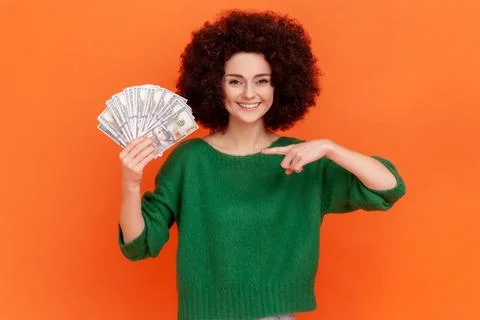 Portrait of gratified rich woman with Afro hairstyle wearing green sweater Stock Photos