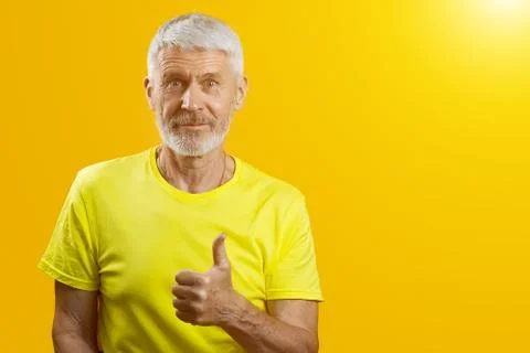 Portrait of a gray-haired man with a beard shows gesture good on blue background 写真素材