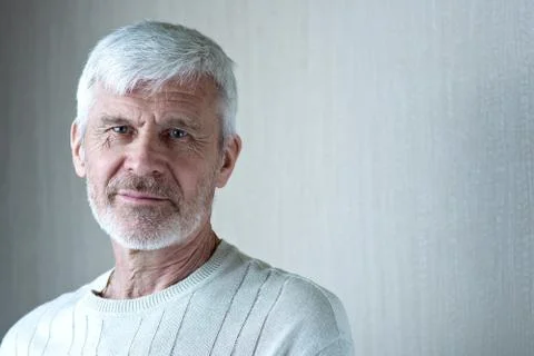 Portrait of gray-haired man in light clothes and glasses Stock Photos