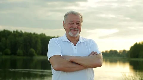 Portrait of a gray-haired senior man with a beard looks at the camera and smiles Stock Footage 169065848