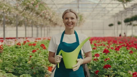 Portrait of the greenhouse gardener looking at the camera. Female gardener Stock Footage 213940834