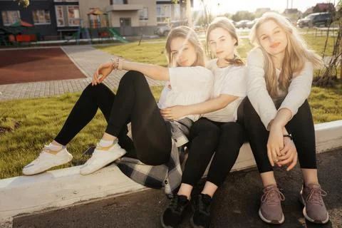 Portrait of a group of happy three different young women sitting and hugging Stock Photos