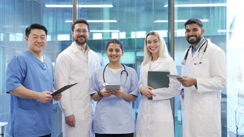 Portrait of group of smiling doctors standing in hospital clinic office looking  Stock Footage 301973640