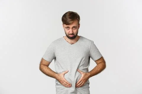 Portrait of guy feeling upset about his weight, showing fat on belly and looking Stock Photos