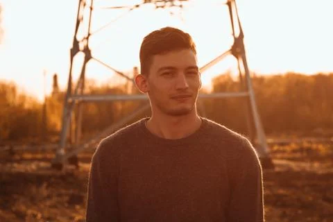 Portrait of a guy in the field on a sunset background Stock Photos