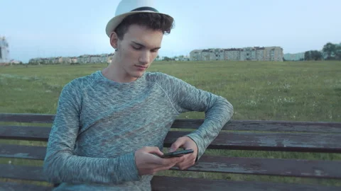 Portrait of a guy with a hat and an earring in his ear, who sits on an old Stock Footage 165707378
