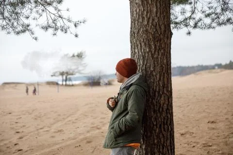 Portrait of a guy in a jacket and a cap by a tree Stock Photos