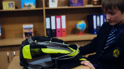 Portrait of a guy picking up a backpack talking in a classroom school education Stock Footage 99255926