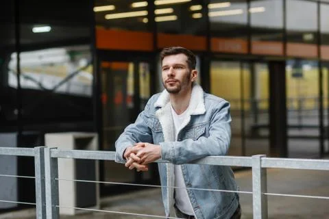 Portrait of a guy in stylish clothes on a background of city streets Stock Photos