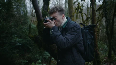 Portrait of guy taking photos in the forest, film photographer in forest Stock Footage 147724774