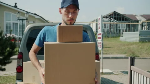 Portrait of guy in uniform delivering cargo unloading van and carrying parcels Stock Footage 157306829