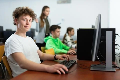 Portrait of guy working at computer in computer class at school Stock Photos