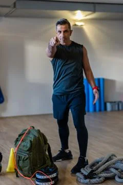 Portrait of gym instructor pointing at camera for gym concept. Focus on finger. Stock Photos