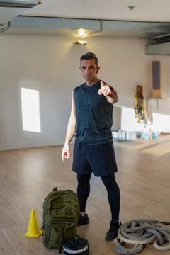 Portrait of gym instructor pointing at camera for gym concept. Stock Photos