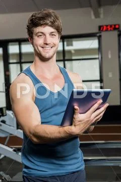 Portrait Of Gym Trainer Using A Digital Tablet