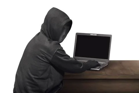 Portrait of hacker man with mask looking back while typing laptop on desk Stock-Fotos
