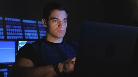 Portrait of hacker programmer working on computer in a data center filled with Stock Footage 102921223