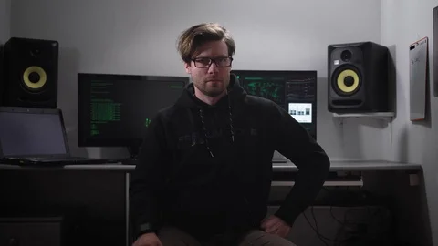 Portrait of a hacker sitting on the chair with computer monitors Stock Footage 72415139
