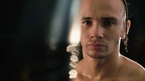 Portrait of hairless with pigtail and tattoos, free fighter at punching bag 4K Stock Footage