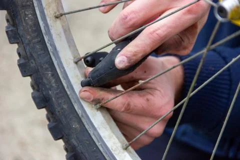 A portrait of the hands of a person using a small bike pump to blow up a flat Stock Photos