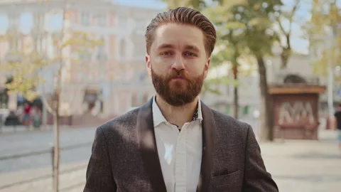 Portrait handsome bearded man use phone look at camera on old city street Stock Footage 140479219