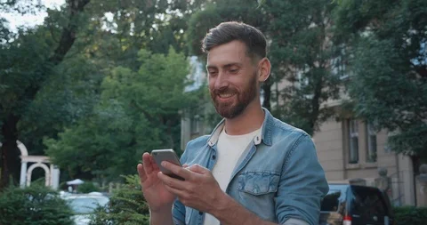 Portrait of Handsome Bearded Man Working on his Smartphone Outdoor. Using Mobile Stock Footage 122992791