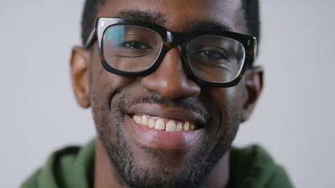 Portrait of handsome black man in glasses looking to camera before smiling, in s Stock Footage