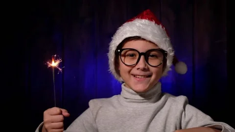 Portrait of handsome boy in red hat and glasses with a sparkler in his hand. Stock Footage 163770007