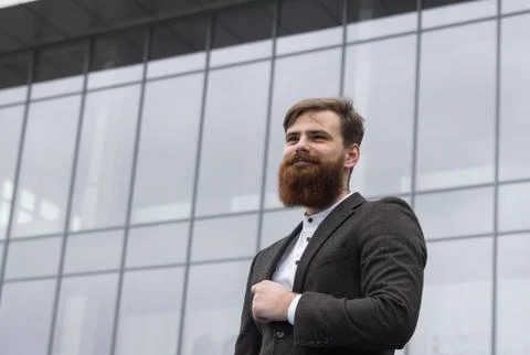 Portrait of an handsome businessman wearing jacket over office building in Stock Photos