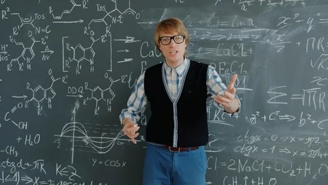 Portrait of handsome guy maths teacher talking looking at camera near chalkboard Stock Footage 125077151