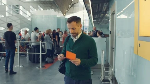 Portrait of a handsome man checking the time on the phone while waiting for his Stock Footage 108868988