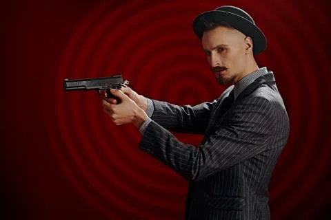 Portrait of a handsome man in elegant classical suit and a hat holding the gu Stock Photos