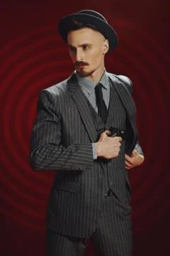 Portrait of a handsome man in elegant classical suit and a hat standing in th Stock Photos