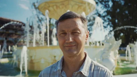 Portrait handsome man look at camera smile feel happy near the fountain at Stock Footage 116997328