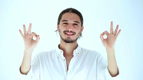 Portrait of handsome man looking at camera smiling, shows ok gesture Stock Footage 135605278
