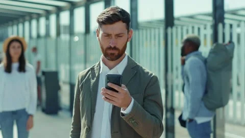 Portrait handsome man use smartphone look at camera smiling on bus stop Stock Footage 138122375
