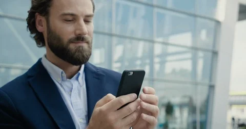Portrait of Handsome Man is using his Phone after he smiles to the Camera Stock Footage 117688481