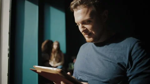 Portrait of the handsome man which works with the tablet Stock Footage 62549677