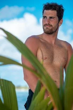 Portrait of handsome man with white teeth smile, shirtless surfer and blue oc Stock Photos