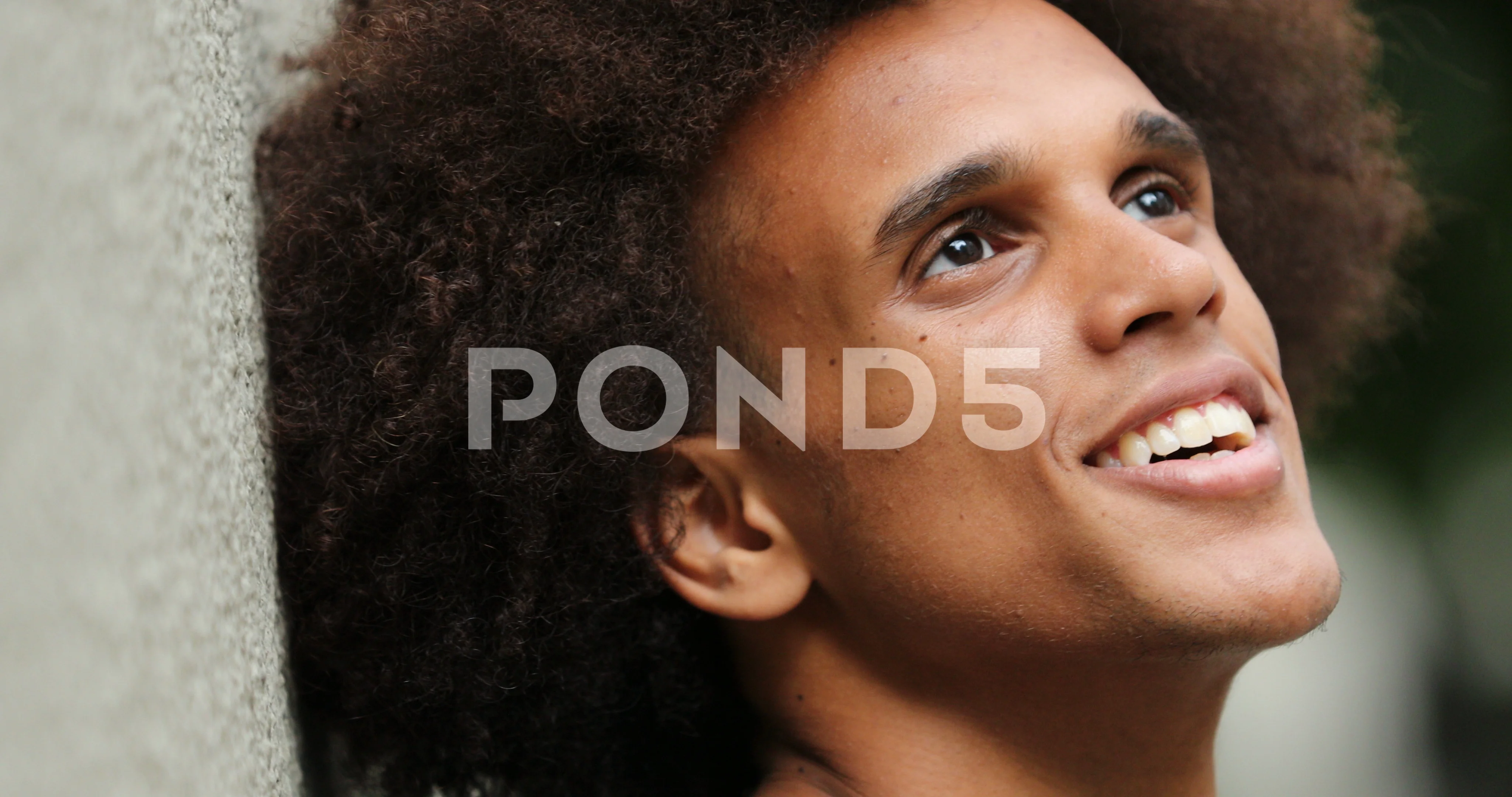 Portrait of handsome mixed race african man looking to sky while leaning to  w